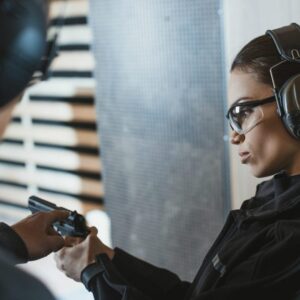 A woman wearing headphones and a gun